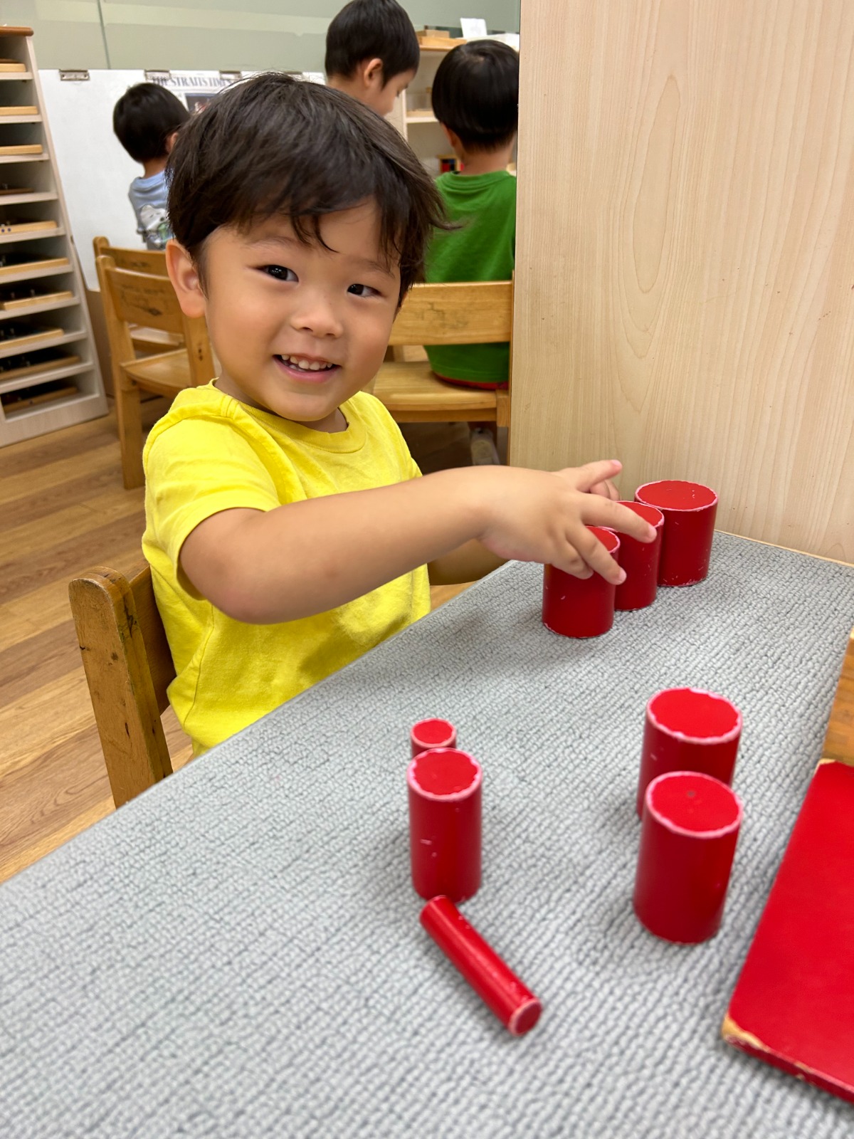 A child concentrating on Montessori cylinder blocks