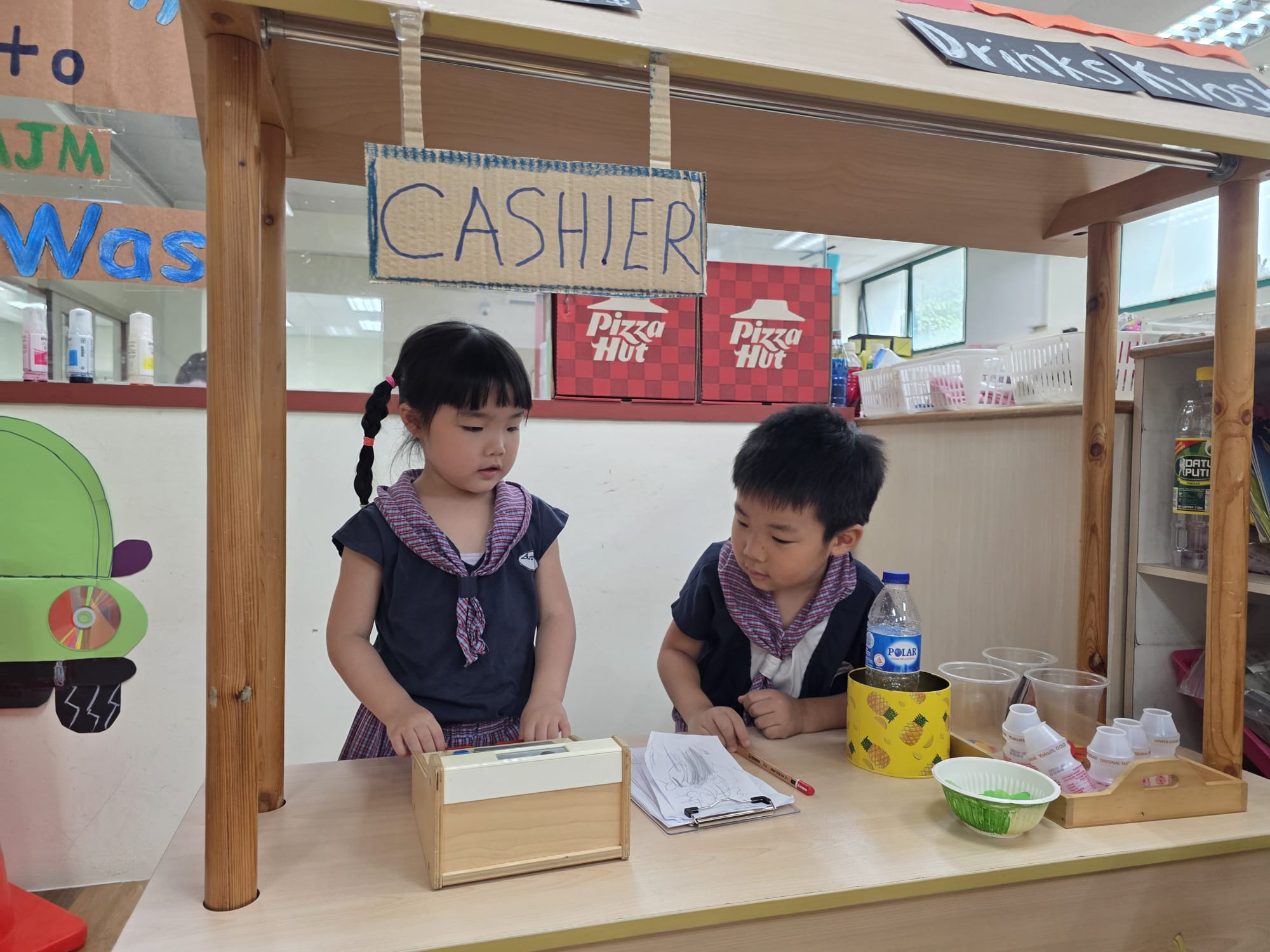 Children playing shop together in the classroom