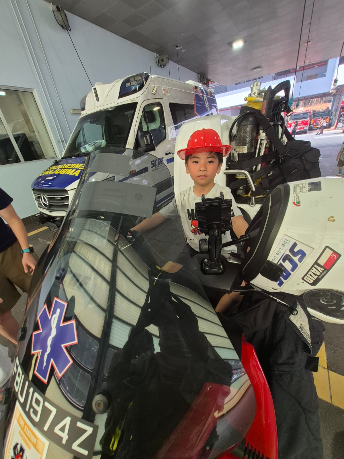 Child in a red helmet sitting on an emergency response motorcycle