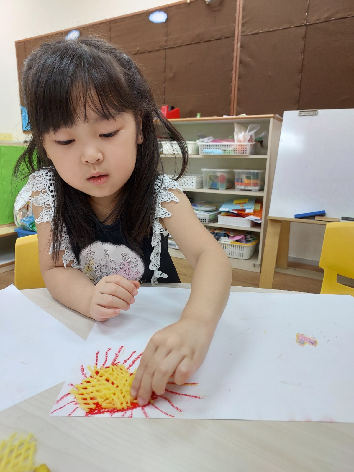 A child finishing a collage artwork